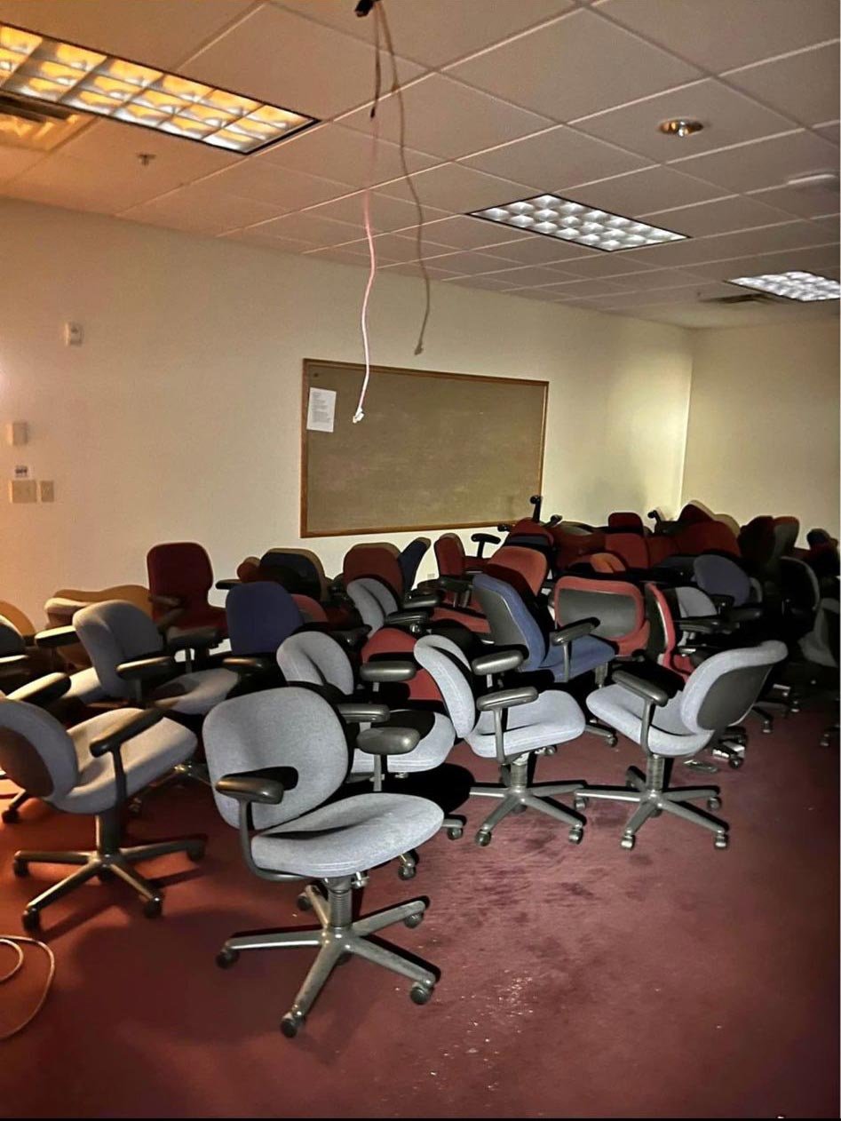 Office task chairs stacked and sorted for donation and office furniture disposal