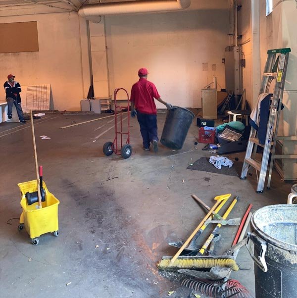 Uniformed crew clearing and cleaning a commercial space on move-out day